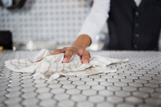 Mid section of waiter cleaning bar counter